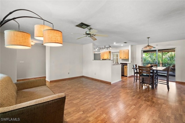 living room with visible vents, ceiling fan, baseboards, and wood finished floors