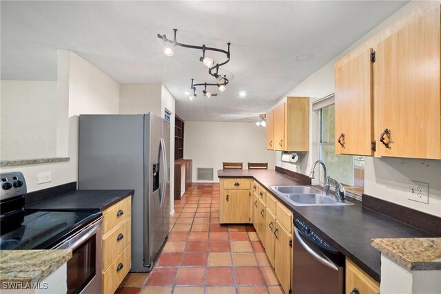 kitchen featuring light brown cabinets, appliances with stainless steel finishes, a sink, and visible vents