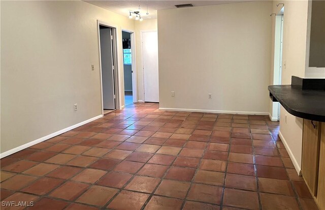 interior space featuring baseboards, visible vents, and tile patterned floors