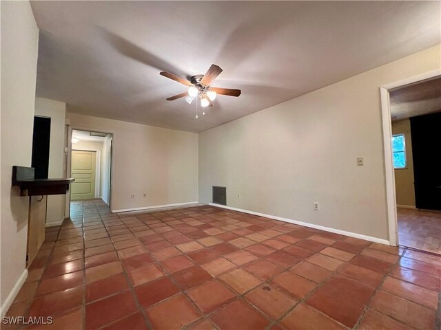 empty room with baseboards, tile patterned flooring, visible vents, and a ceiling fan