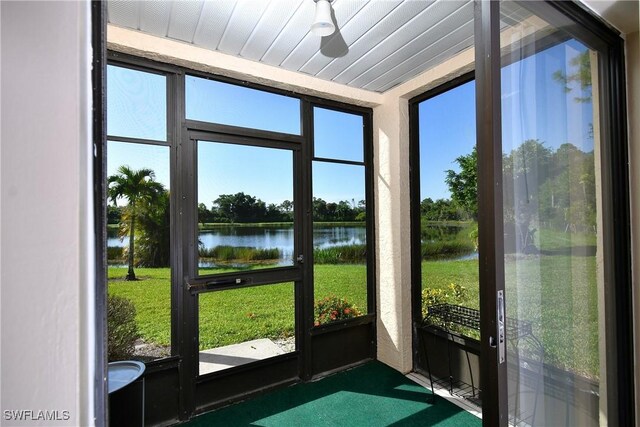 sunroom featuring a water view