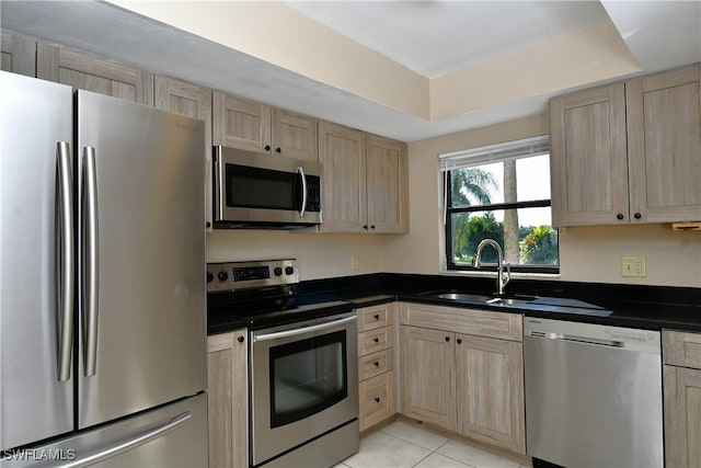 kitchen with light brown cabinets, appliances with stainless steel finishes, and light tile patterned floors