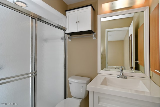 bathroom featuring toilet, an enclosed shower, and vanity