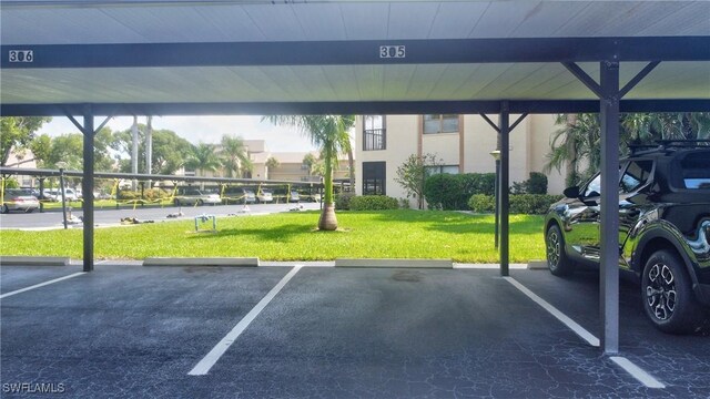 view of vehicle parking with a carport and a lawn