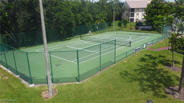 view of tennis court featuring a lawn