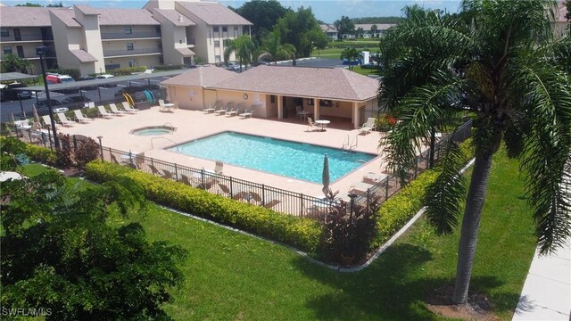 view of pool featuring a patio area, a lawn, and a hot tub