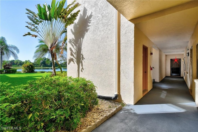 view of side of home featuring a lawn and a water view