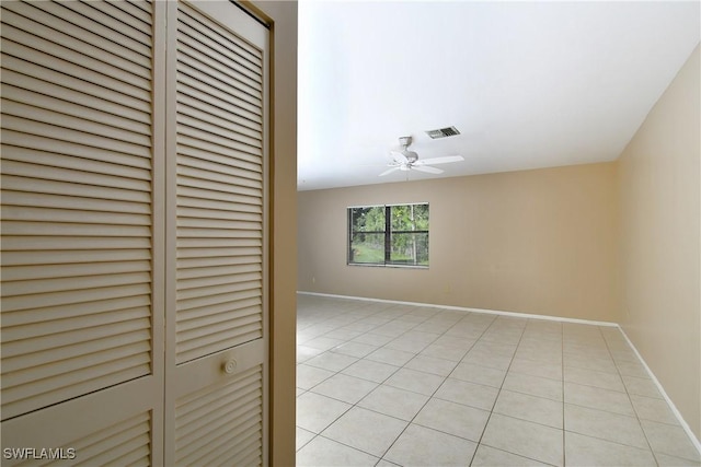 tiled empty room featuring ceiling fan