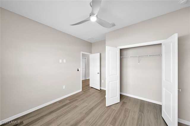 unfurnished bedroom featuring ceiling fan, hardwood / wood-style floors, and a closet