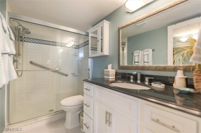 bathroom with tile patterned flooring, a shower with shower door, toilet, and vanity