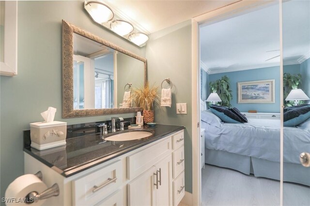 bathroom with crown molding, vanity, and hardwood / wood-style floors