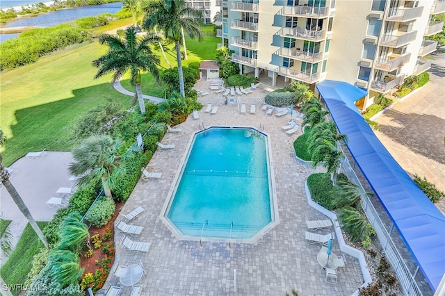 view of swimming pool with a water view, a lawn, and a patio