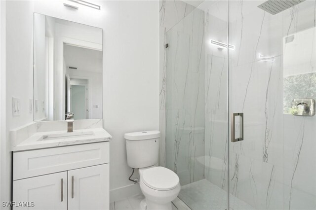 bathroom with tile patterned floors, a shower with shower door, vanity, and toilet