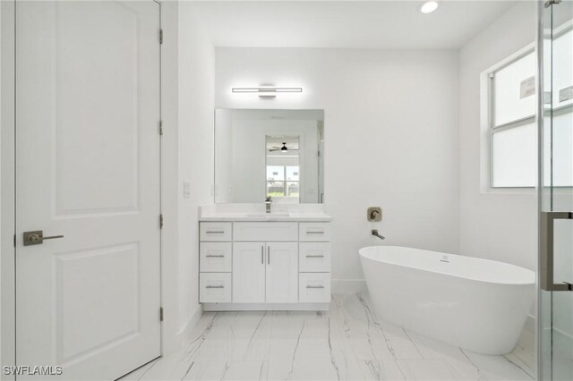 bathroom with tile patterned floors, vanity, and a tub to relax in