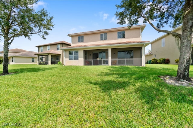 back of property with a sunroom and a yard