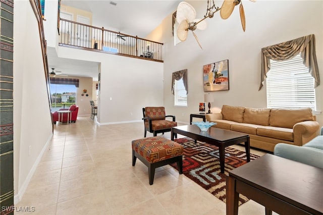 tiled living room featuring ceiling fan and a high ceiling