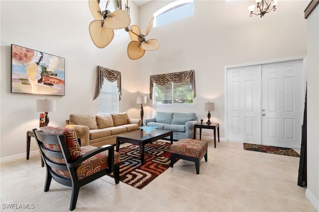 living room featuring an inviting chandelier, light tile patterned flooring, and a high ceiling