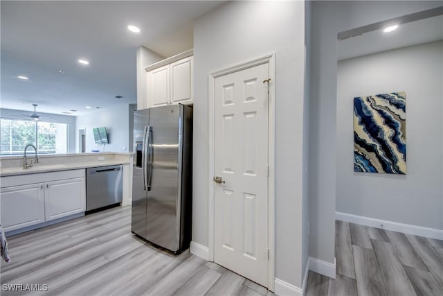 kitchen featuring white cabinetry, appliances with stainless steel finishes, sink, and light hardwood / wood-style floors