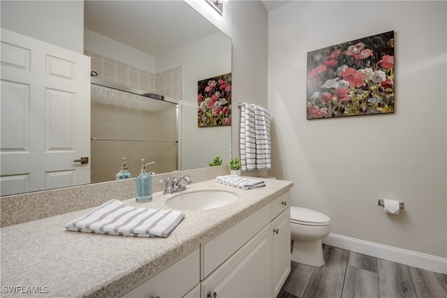 bathroom featuring wood-type flooring, toilet, and vanity