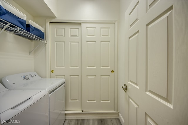 laundry room featuring light hardwood / wood-style flooring and washing machine and dryer