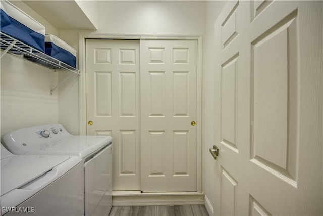 washroom featuring washing machine and dryer and light wood-type flooring