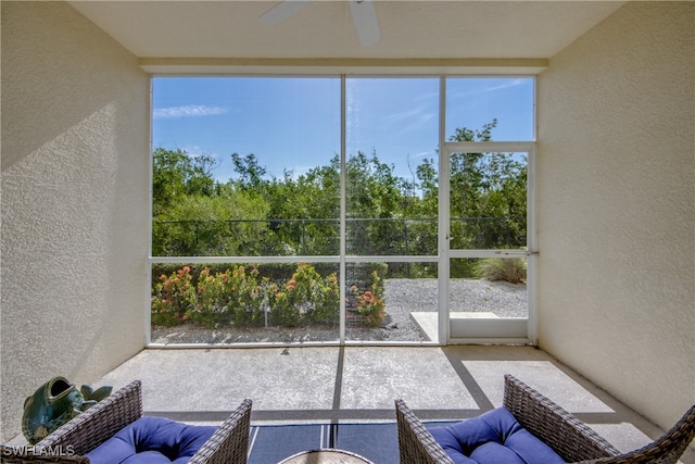 unfurnished sunroom with ceiling fan