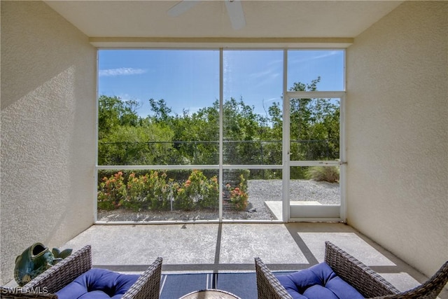 unfurnished sunroom featuring ceiling fan