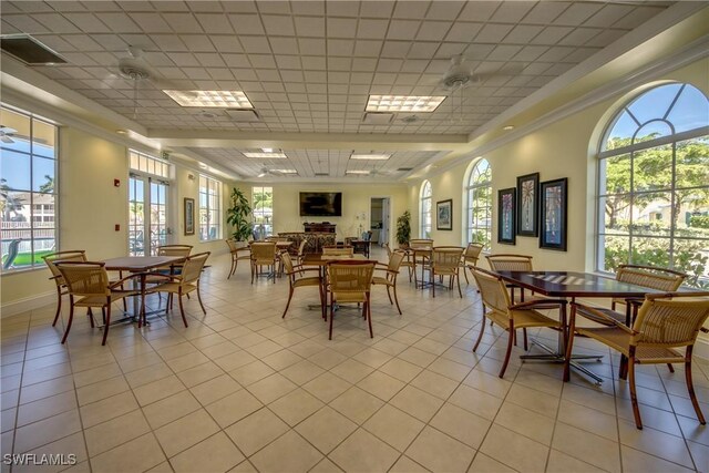 tiled dining area with ceiling fan and a paneled ceiling