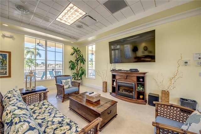 living room with a paneled ceiling, a tray ceiling, and light tile patterned floors