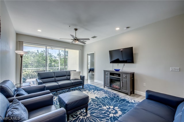 living room with light hardwood / wood-style floors and ceiling fan