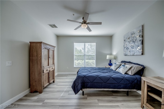 bedroom with light hardwood / wood-style flooring, ceiling fan, and a closet