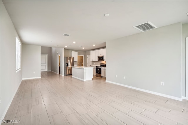 unfurnished living room featuring light hardwood / wood-style flooring and sink