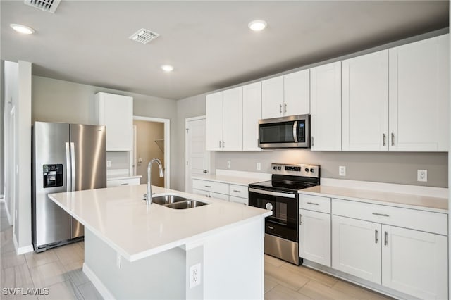 kitchen with white cabinets, a kitchen island with sink, stainless steel appliances, and sink