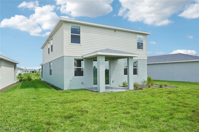 back of house with a lawn and a patio