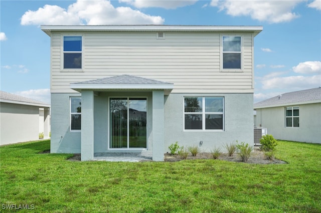 rear view of house featuring a lawn and central air condition unit