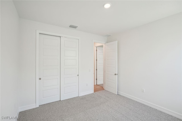 unfurnished bedroom with carpet floors and a closet