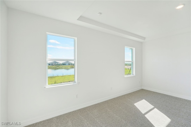 empty room with a water view and carpet floors