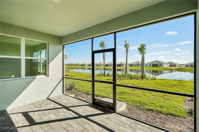 sunroom featuring a water view