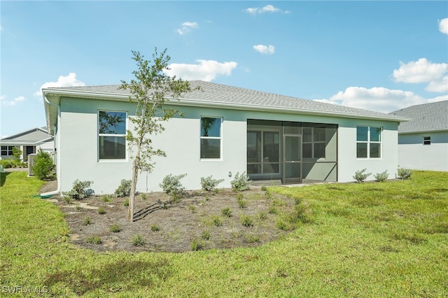 rear view of house with a sunroom and a yard