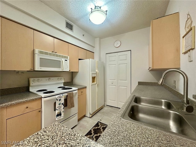 kitchen featuring sink, light brown cabinets, a textured ceiling, light tile patterned floors, and white appliances