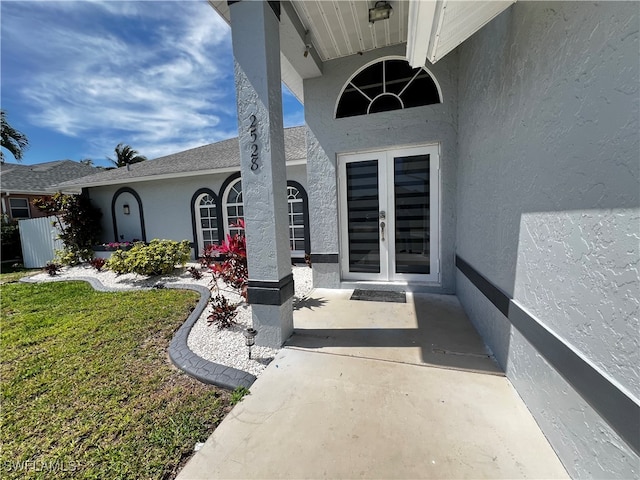 property entrance featuring a lawn and french doors