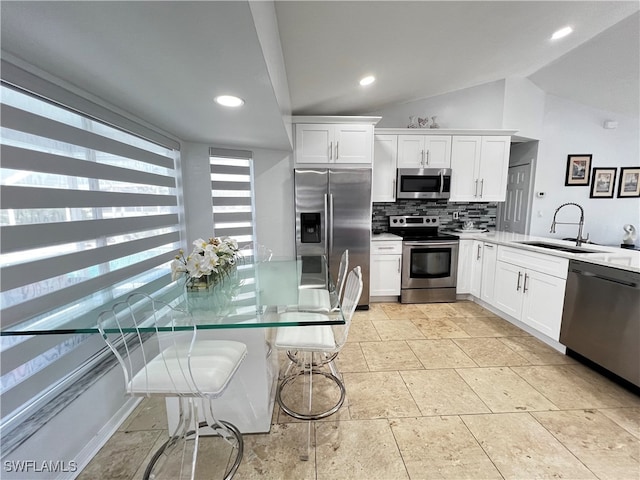 kitchen featuring backsplash, sink, white cabinetry, appliances with stainless steel finishes, and light tile patterned floors