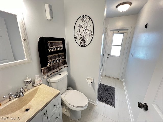 bathroom featuring tile patterned flooring, toilet, and vanity