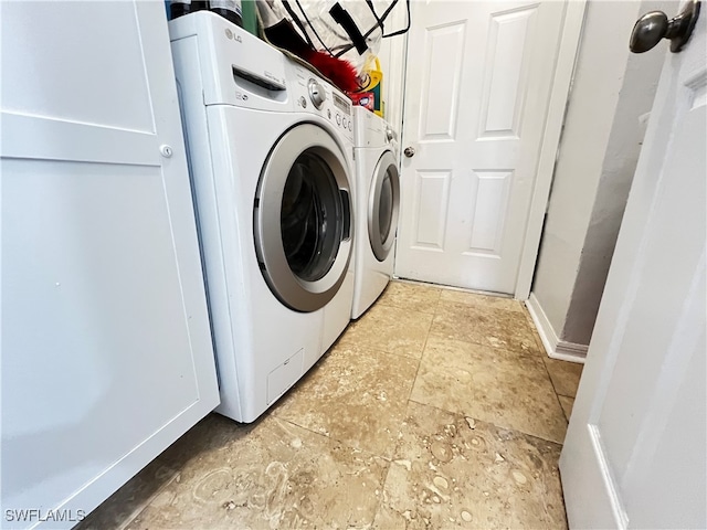 laundry area with washing machine and dryer and light tile patterned floors