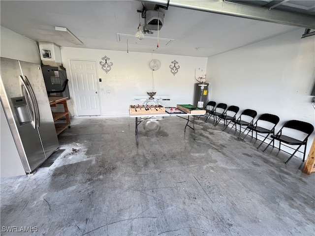 garage with stainless steel refrigerator with ice dispenser, a garage door opener, and water heater