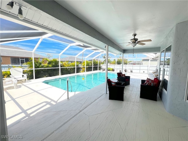 view of pool featuring ceiling fan, a lanai, and a patio area