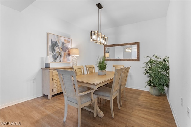 dining room with light hardwood / wood-style floors and a chandelier