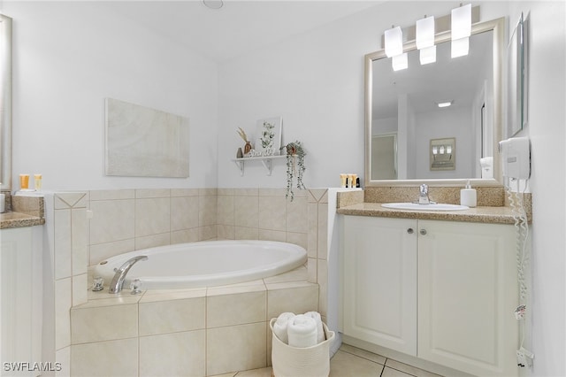 bathroom featuring tiled bath, tile patterned floors, and vanity