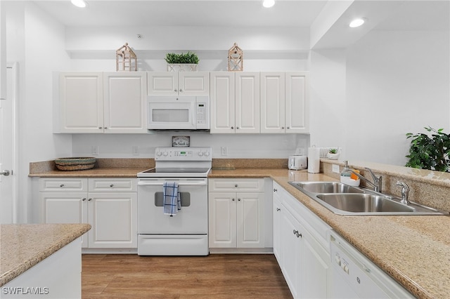 kitchen featuring sink, white appliances, white cabinets, and light hardwood / wood-style flooring