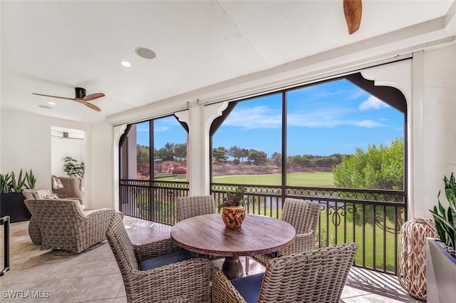 sunroom / solarium featuring a water view and ceiling fan